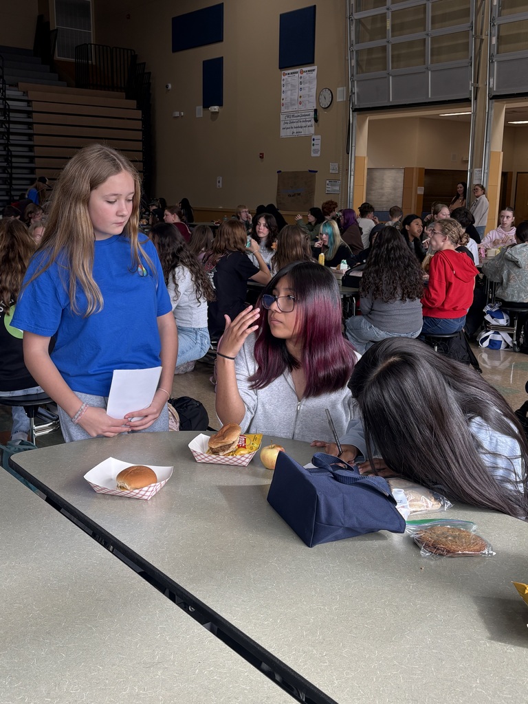 Cascade Middle School students participate in a Sources of Strength “You Belong” campaign during lunch. Students hold signed pledge sheets promoting encouragement, respect for different backgrounds and experiences, and a commitment to helping others feel that they belong in their school community.
