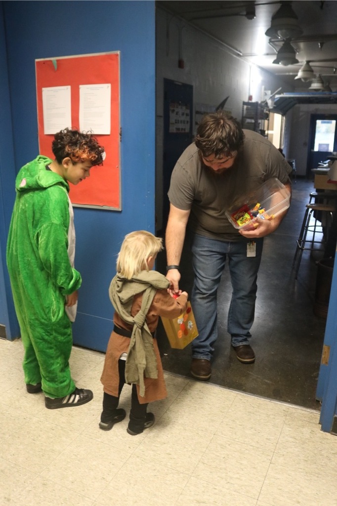 Preschool students from the Cubs Early Learning Academy, dressed in a variety of Halloween costumes, trick-or-treat through the hallways of Sedro-Woolley High School, visiting classrooms and collecting candy during a festive Halloween celebration.