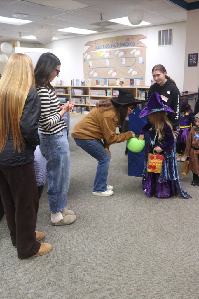 Preschool students from the Cubs Early Learning Academy, dressed in a variety of Halloween costumes, trick-or-treat through the hallways of Sedro-Woolley High School, visiting classrooms and collecting candy during a festive Halloween celebration.