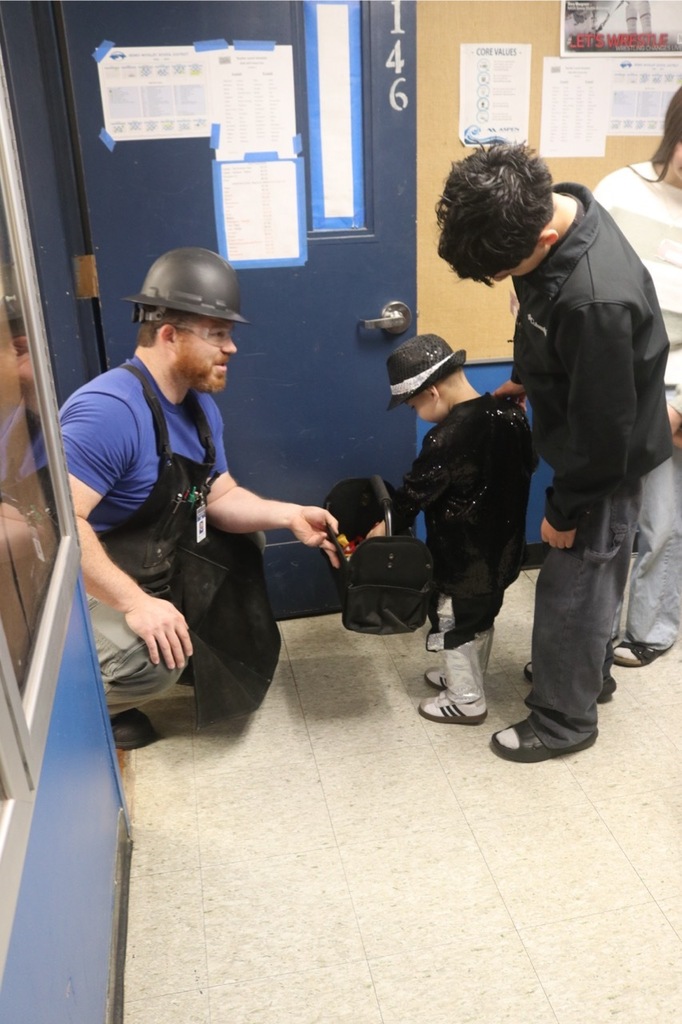 Preschool students from the Cubs Early Learning Academy, dressed in a variety of Halloween costumes, trick-or-treat through the hallways of Sedro-Woolley High School, visiting classrooms and collecting candy during a festive Halloween celebration.