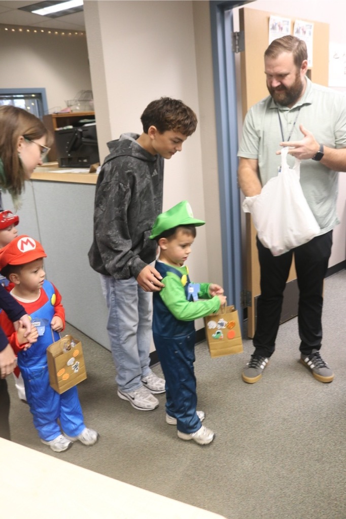 Preschool students from the Cubs Early Learning Academy, dressed in a variety of Halloween costumes, trick-or-treat through the hallways of Sedro-Woolley High School, visiting classrooms and collecting candy during a festive Halloween celebration.