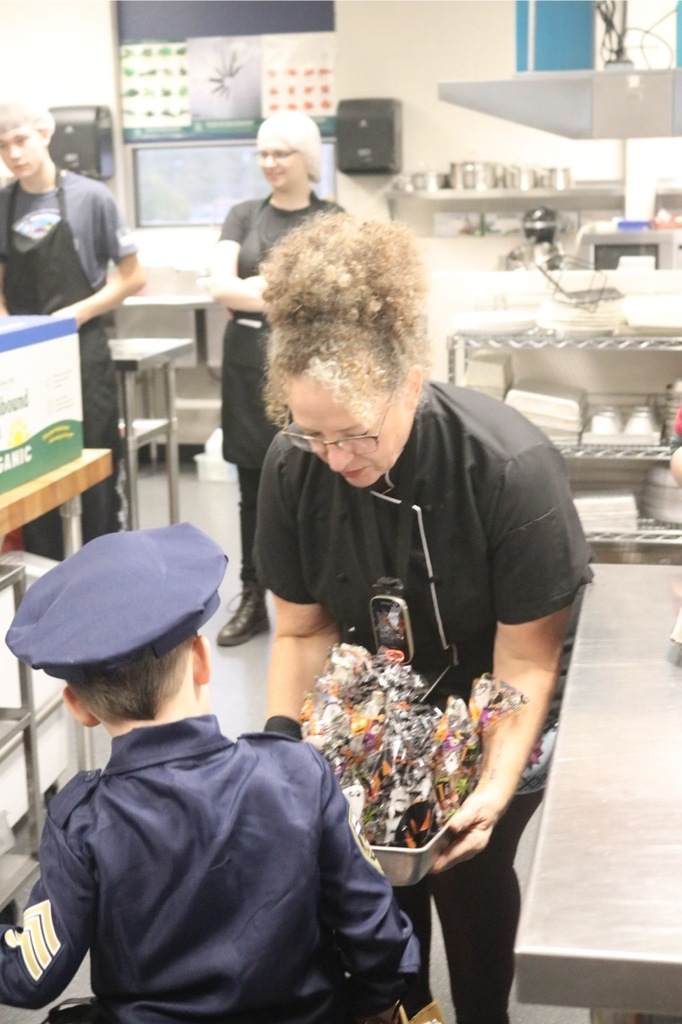 Preschool students from the Cubs Early Learning Academy, dressed in a variety of Halloween costumes, trick-or-treat through the hallways of Sedro-Woolley High School, visiting classrooms and collecting candy during a festive Halloween celebration.