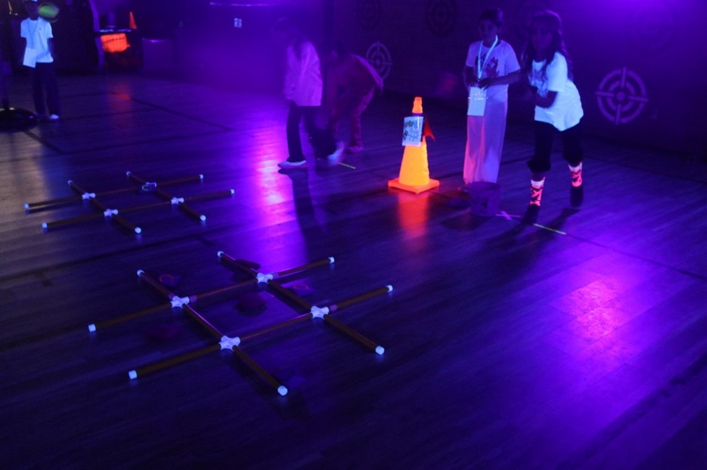 Trick-Tac-Toe: Students participate in a Halloween-themed tic-tac-toe game under glowing black lights during Evergreen STEM Elementary's Glow Day.