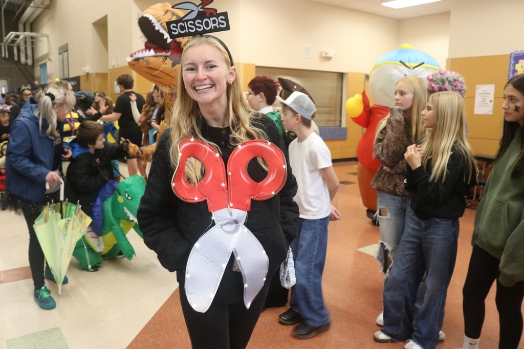 Evergreen Elementary School students dressed in Halloween costumes parade through the hallways of Cascade Middle School. Middle school students, many also in costume, line the hallways to exchange high fives and fist bumps with younger students. Other photos capture happy reunions between former Evergreen students and staff members.