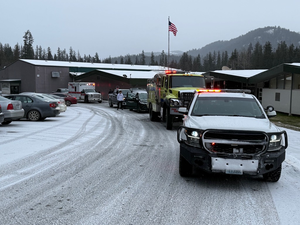 caravan departing from school with flag in background