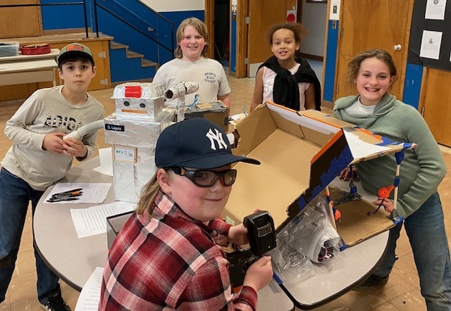 4th graders with inventions at a table