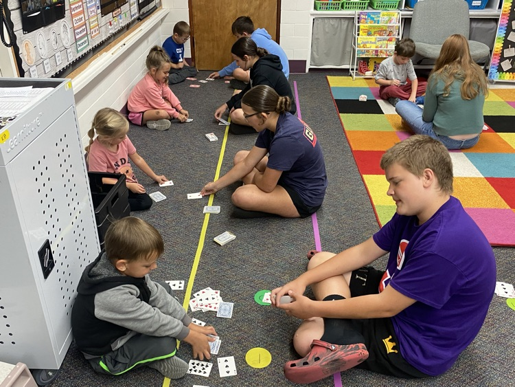 Eighth graders partnered with kindergarten today to learn a fun new card game that helps practice comparing bigger and smaller numbers.