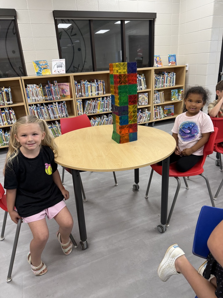 Miss Jodi Harper and Miss Jalee’ Conley’s class had an enrichment activity in the library. Mrs. Godwin read, “No Lie, Pigs (And Their Houses) Can Fly!” and a non fiction book about pigs. Students had to identify the characters and the setting of the story and the difference between fiction and non fiction texts. After the story, students had to create their own houses (setting) around a pig (character) taped to the tables. Items to build the houses included magnatiles, magnetic blocks, cups, dominoes, lincoln logs, fake bricks, and fake cement blocks. The idea was to make it strong enough not to get blown down. Miss Jodi used a hair dryer as the Big Bad Wolf. The class had lots of fun with this activity. 