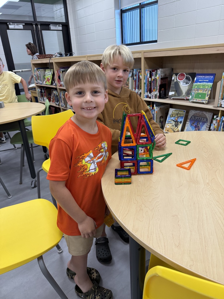 Miss Jodi Harper and Miss Jalee’ Conley’s class had an enrichment activity in the library. Mrs. Godwin read, “No Lie, Pigs (And Their Houses) Can Fly!” and a non fiction book about pigs. Students had to identify the characters and the setting of the story and the difference between fiction and non fiction texts. After the story, students had to create their own houses (setting) around a pig (character) taped to the tables. Items to build the houses included magnatiles, magnetic blocks, cups, dominoes, lincoln logs, fake bricks, and fake cement blocks. The idea was to make it strong enough not to get blown down. Miss Jodi used a hair dryer as the Big Bad Wolf. The class had lots of fun with this activity. 
