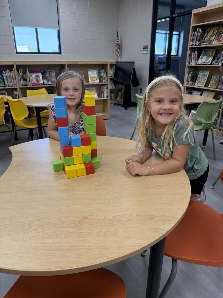 Miss Jodi Harper and Miss Jalee’ Conley’s class had an enrichment activity in the library. Mrs. Godwin read, “No Lie, Pigs (And Their Houses) Can Fly!” and a non fiction book about pigs. Students had to identify the characters and the setting of the story and the difference between fiction and non fiction texts. After the story, students had to create their own houses (setting) around a pig (character) taped to the tables. Items to build the houses included magnatiles, magnetic blocks, cups, dominoes, lincoln logs, fake bricks, and fake cement blocks. The idea was to make it strong enough not to get blown down. Miss Jodi used a hair dryer as the Big Bad Wolf. The class had lots of fun with this activity. 
