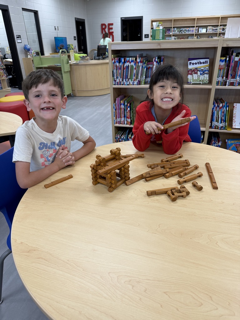Miss Jodi Harper and Miss Jalee’ Conley’s class had an enrichment activity in the library. Mrs. Godwin read, “No Lie, Pigs (And Their Houses) Can Fly!” and a non fiction book about pigs. Students had to identify the characters and the setting of the story and the difference between fiction and non fiction texts. After the story, students had to create their own houses (setting) around a pig (character) taped to the tables. Items to build the houses included magnatiles, magnetic blocks, cups, dominoes, lincoln logs, fake bricks, and fake cement blocks. The idea was to make it strong enough not to get blown down. Miss Jodi used a hair dryer as the Big Bad Wolf. The class had lots of fun with this activity. 