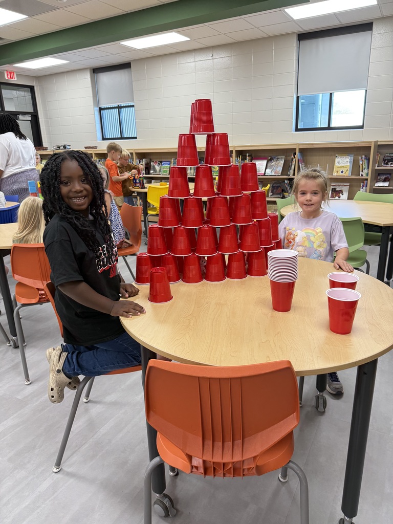 Miss Jodi Harper and Miss Jalee’ Conley’s class had an enrichment activity in the library. Mrs. Godwin read, “No Lie, Pigs (And Their Houses) Can Fly!” and a non fiction book about pigs. Students had to identify the characters and the setting of the story and the difference between fiction and non fiction texts. After the story, students had to create their own houses (setting) around a pig (character) taped to the tables. Items to build the houses included magnatiles, magnetic blocks, cups, dominoes, lincoln logs, fake bricks, and fake cement blocks. The idea was to make it strong enough not to get blown down. Miss Jodi used a hair dryer as the Big Bad Wolf. The class had lots of fun with this activity. 
