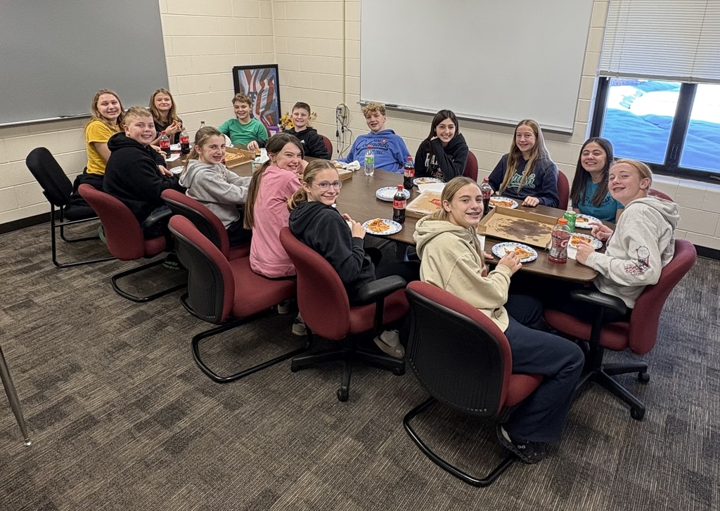 A group of students enjoy pizza and drinks for lunch.  