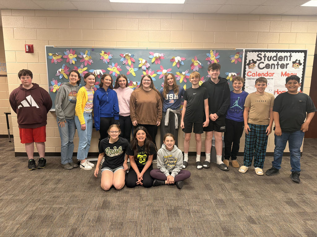 Students pose with cupcakes and their student teacher.  