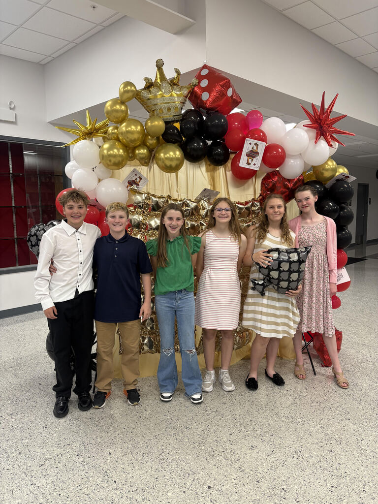 Students pose in front of a balloon arch.  