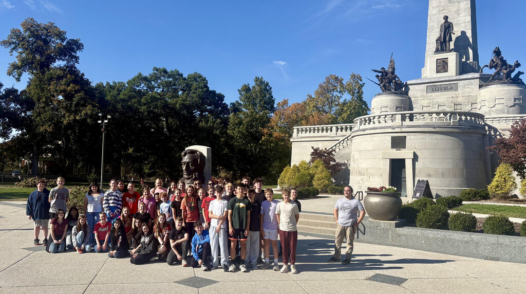 Middle school students pose in front of the tomb of Abraham Lincoln . 