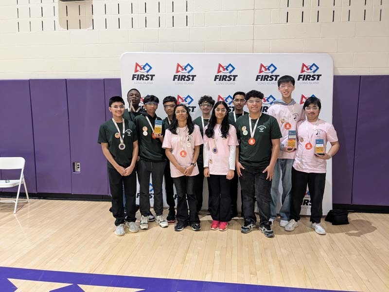 Students standing in front of FIRST banner.