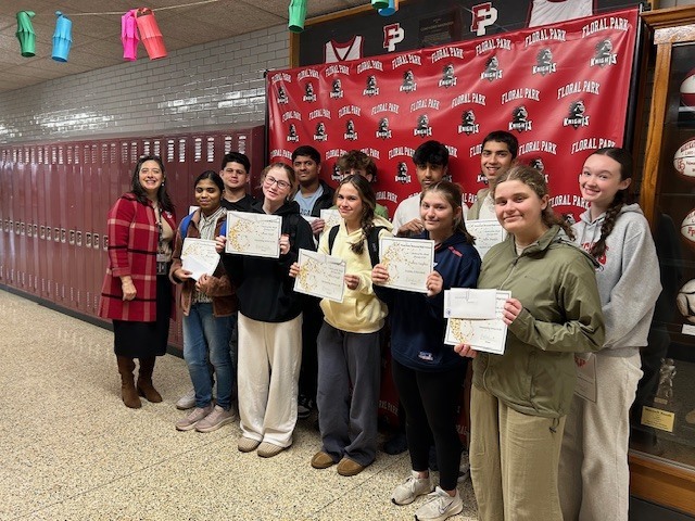 Students holding certificates in hallway.