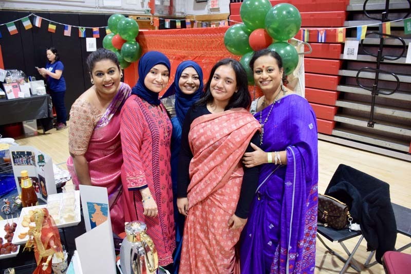 Students dressed in Indian wardrobes smiling for picture.