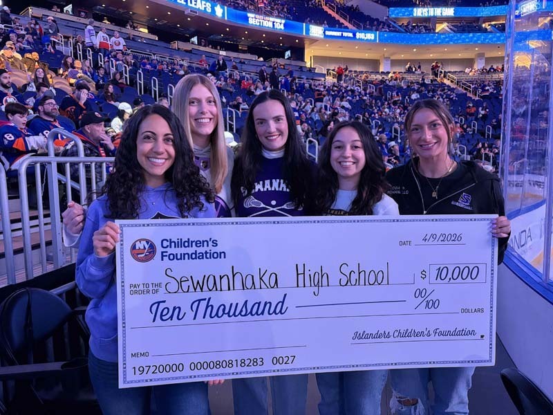 Students and teachers holding large check for $10,000.