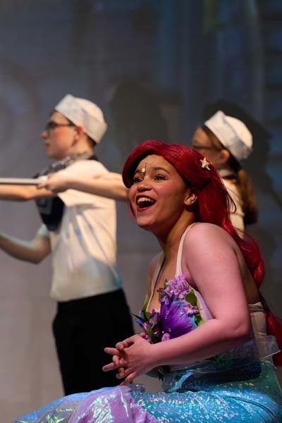 Students in costume on stage.