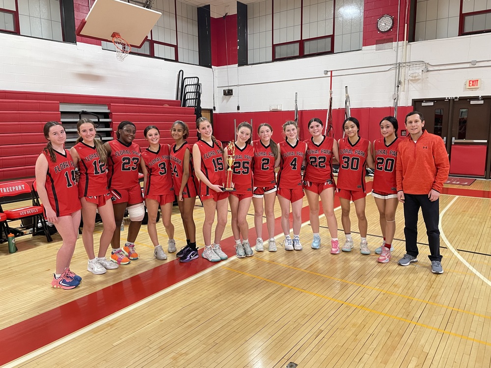 Girls basketball team group photo in gymnasium.