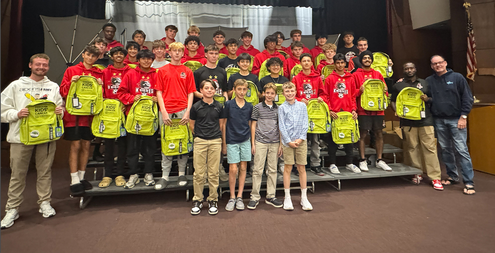 group photo of students in red shirts with yellow bookbags