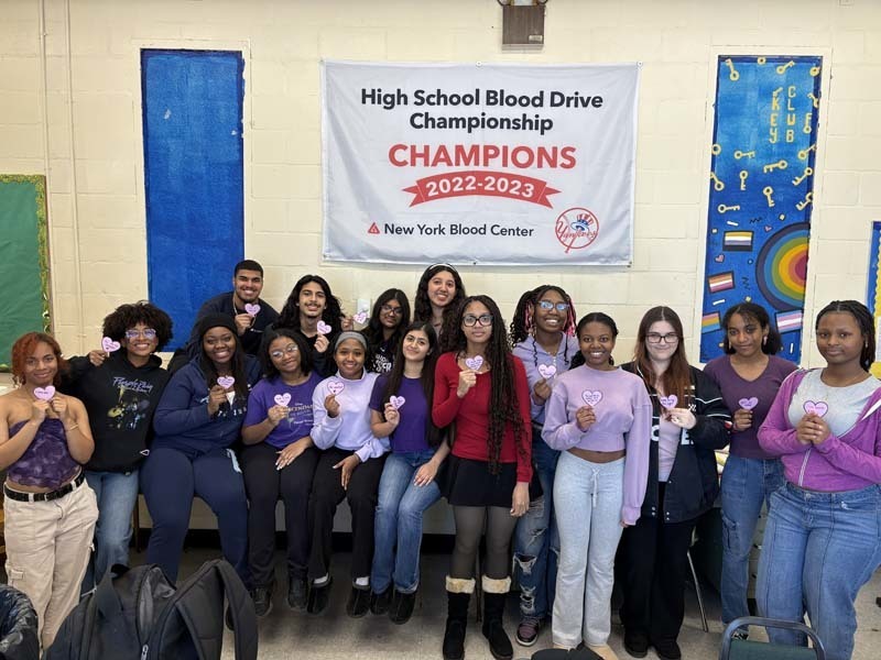 Students standing in front of Blood Drive Champions banner.
