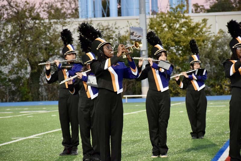 Marching band students performing on field.