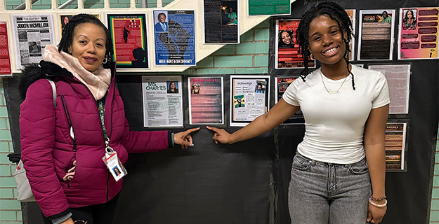 Student and teacher standing with display.