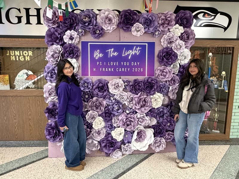 Students standing in front of flower display.