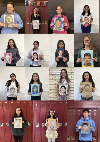 Students holding their artwork.