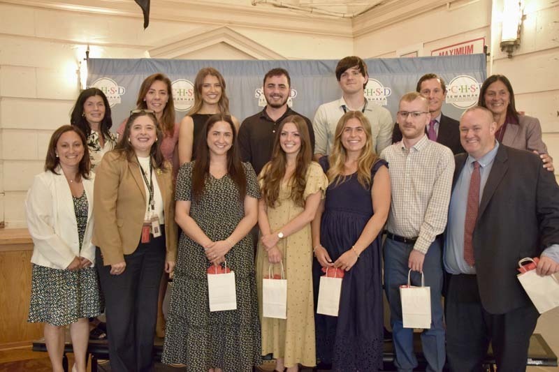 Students holding awards, smiling with BOE members.
