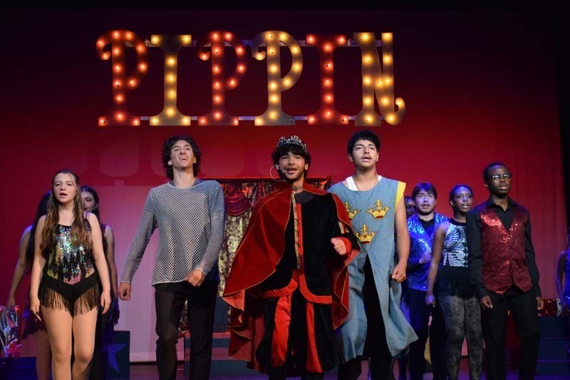 Students performing under Pippin sign.