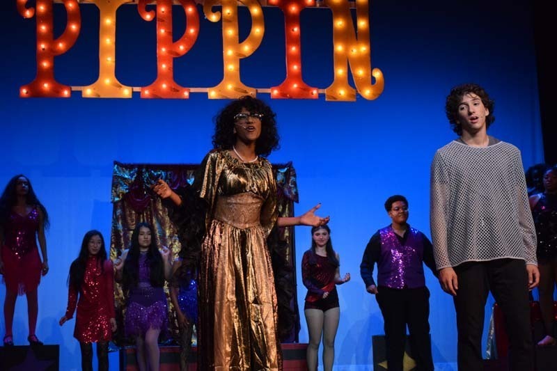 Students performing under Pippin sign.