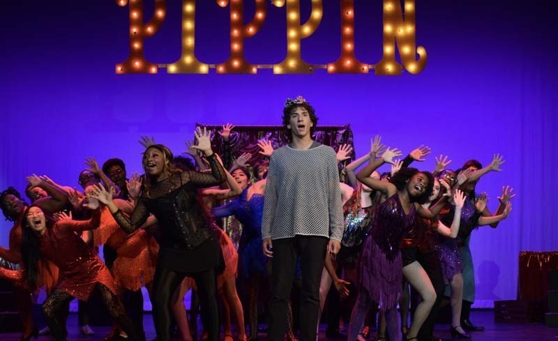 Students performing under Pippin sign.
