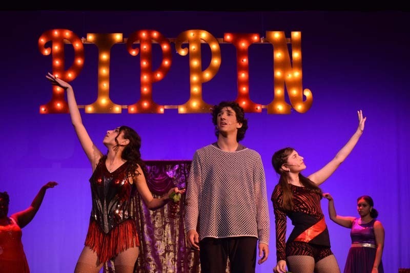 Students performing under Pippin sign.