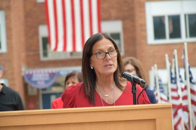 Woman giving speech at podium.