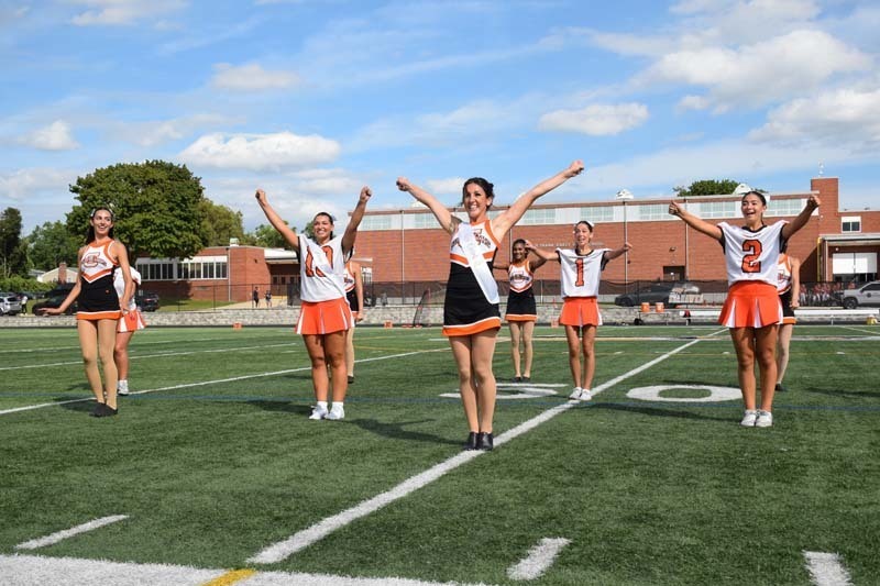 Student cheerleaders performing on field.