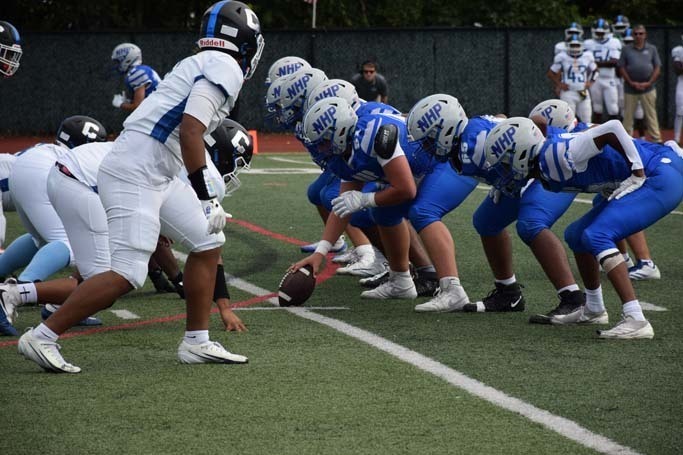 Student football players playing on field.