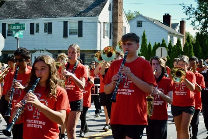 Student band performing while marching in the street.