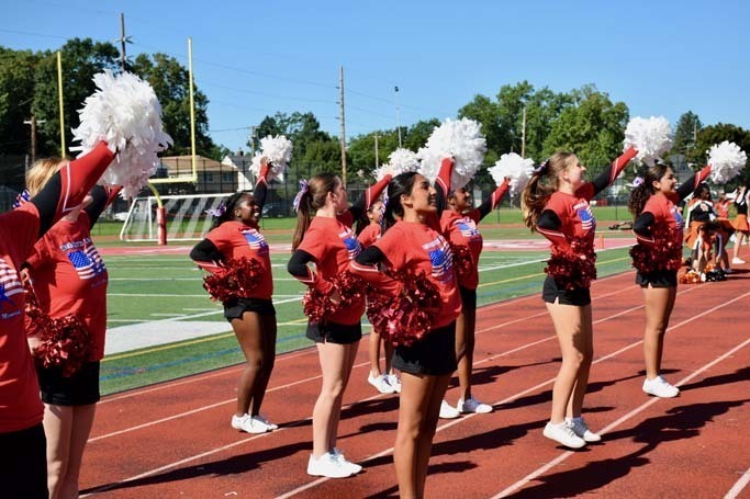 Student cheerleaders performing on field.
