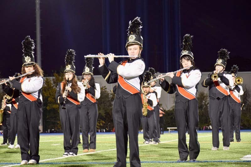 Marching band students performing on field.