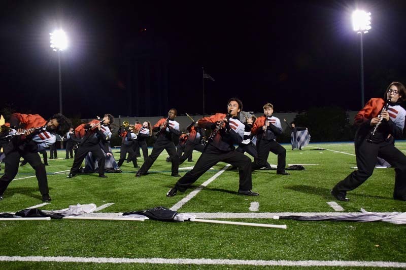 Marching band students performing on field.