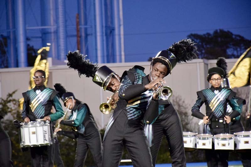 Marching band students performing on field.