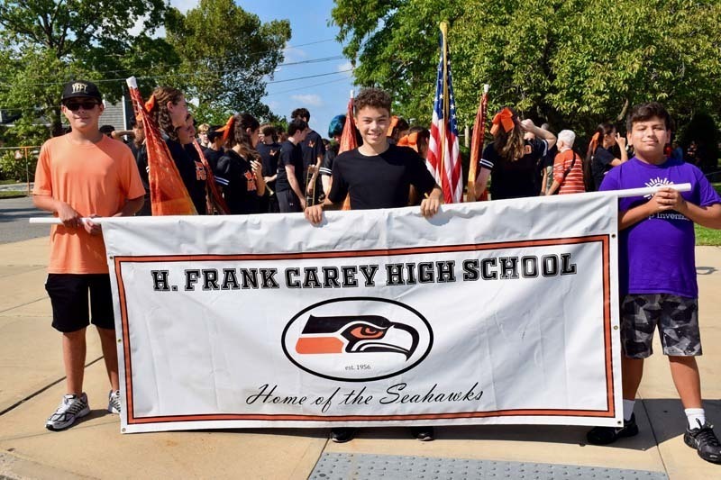 Students hold a school banner and await the homecoming parade.