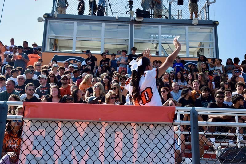 Cheerleader waves to the stands.