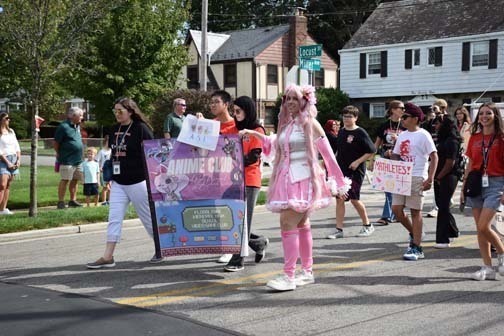 Students holding the school banner await the parade.