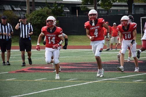 Homecoming Court members smile from a car in the homecoming parade.