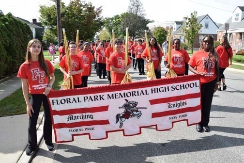 Students holding the school banner await the parade.